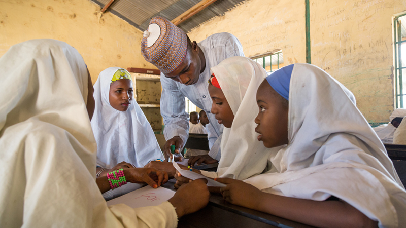 Credit/ALT text: Girls with their teacher at Miga Central Primary School, Nigeria. Credit: GPE/Kelley Lynch